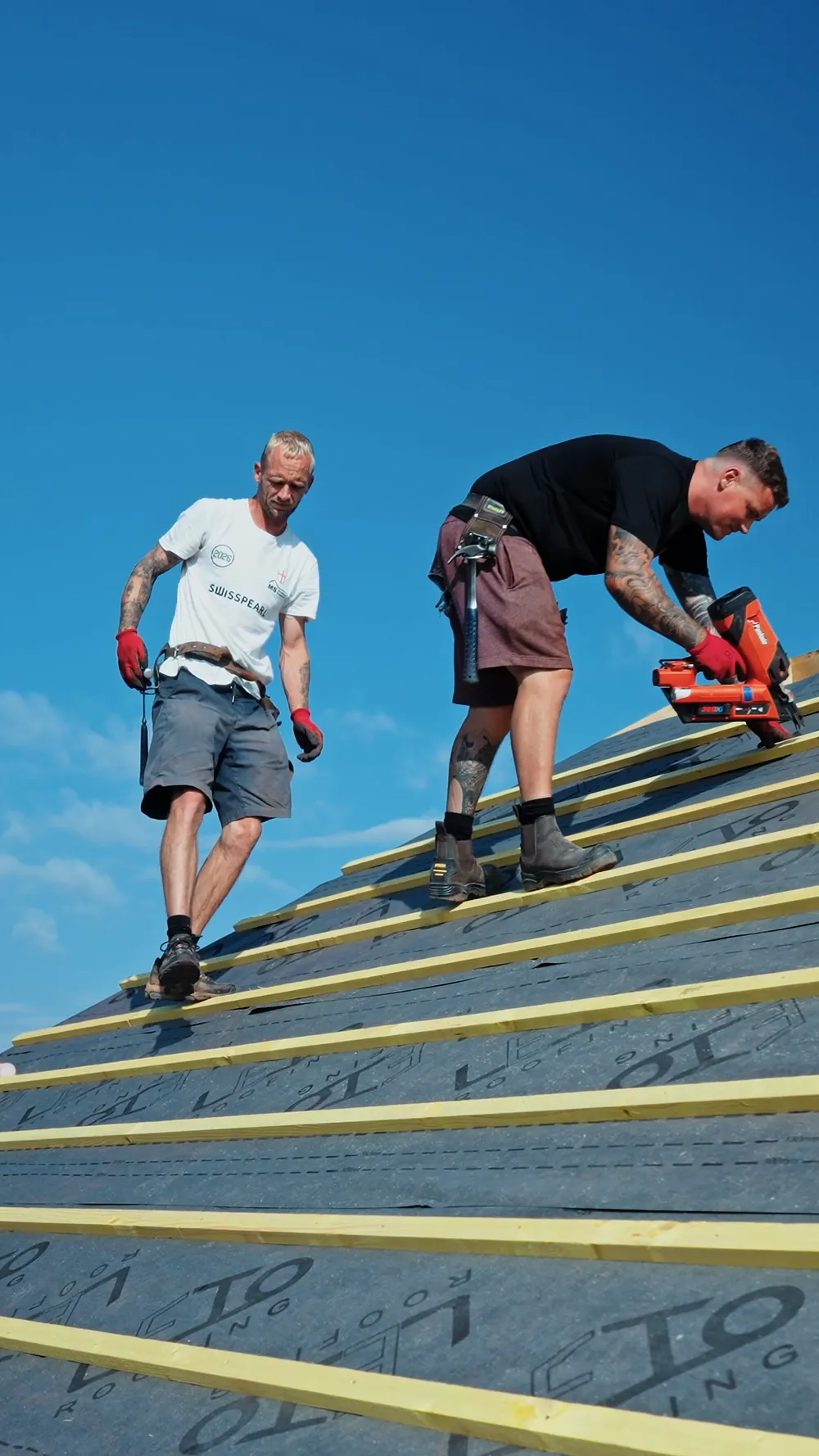 The Build and Co team working on a roof